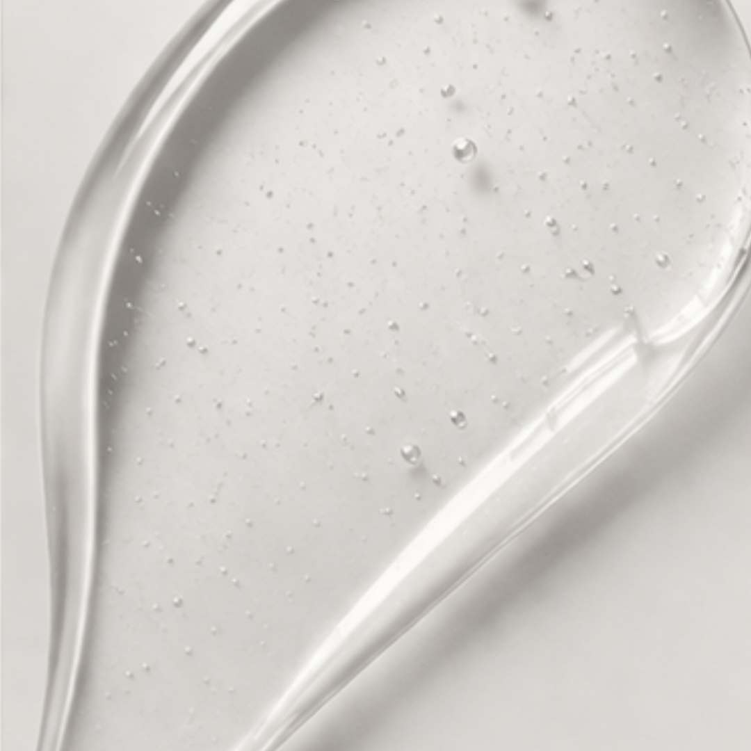 Close-up of a grayish-white gel or cream with a smooth texture on a light gray background